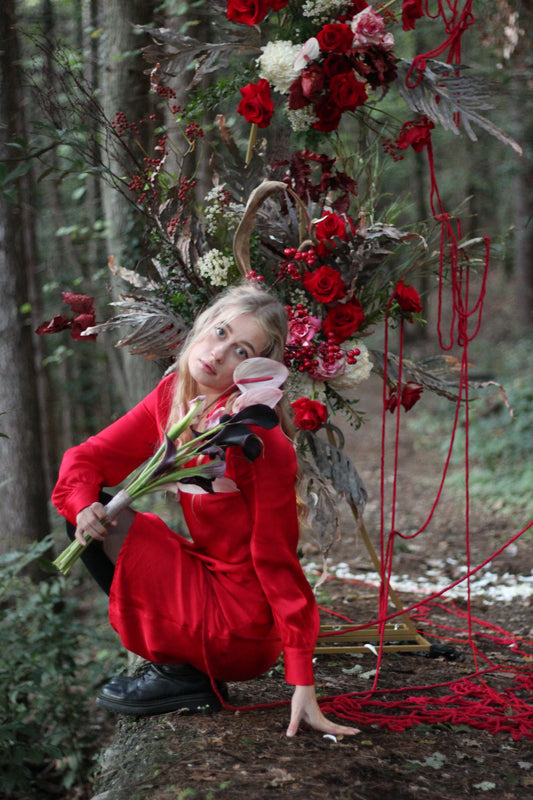 young girl dressed in red with red roses wedding flowers