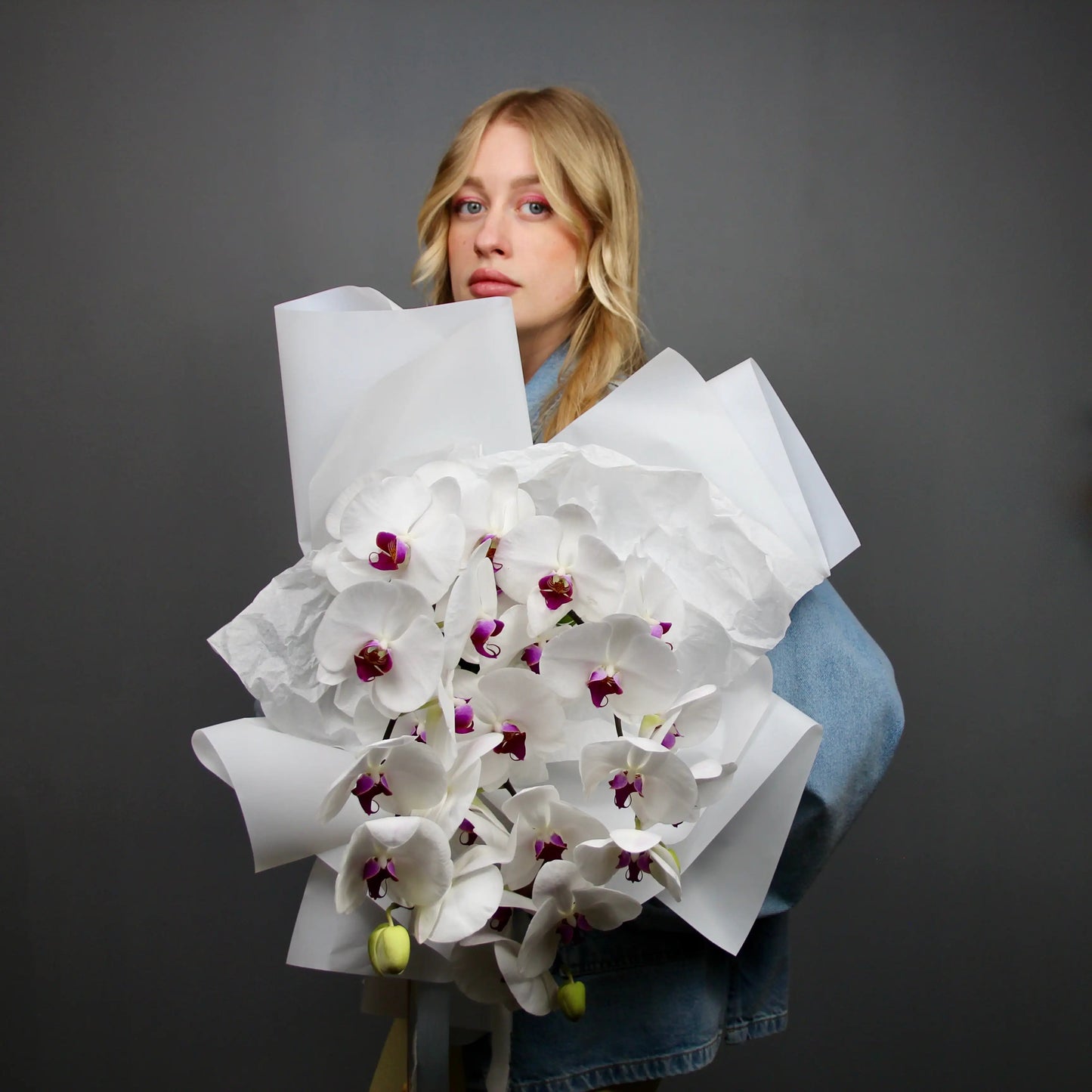 donna tiene un bouquet di orchidee