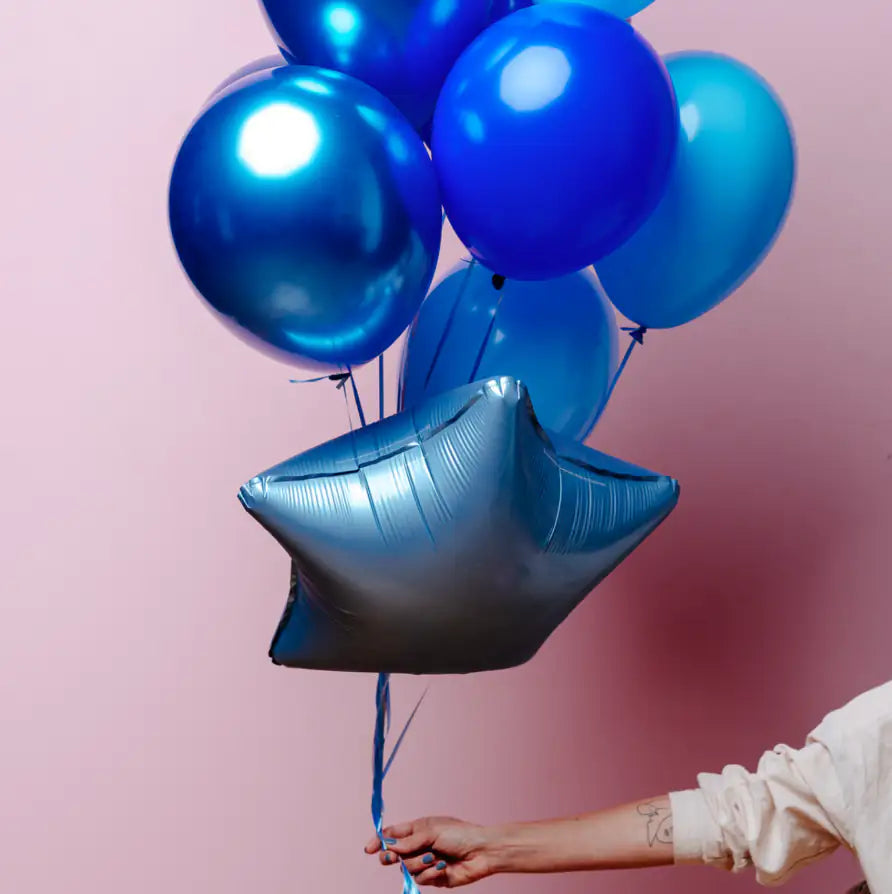 bundle of blue balloons on pink background