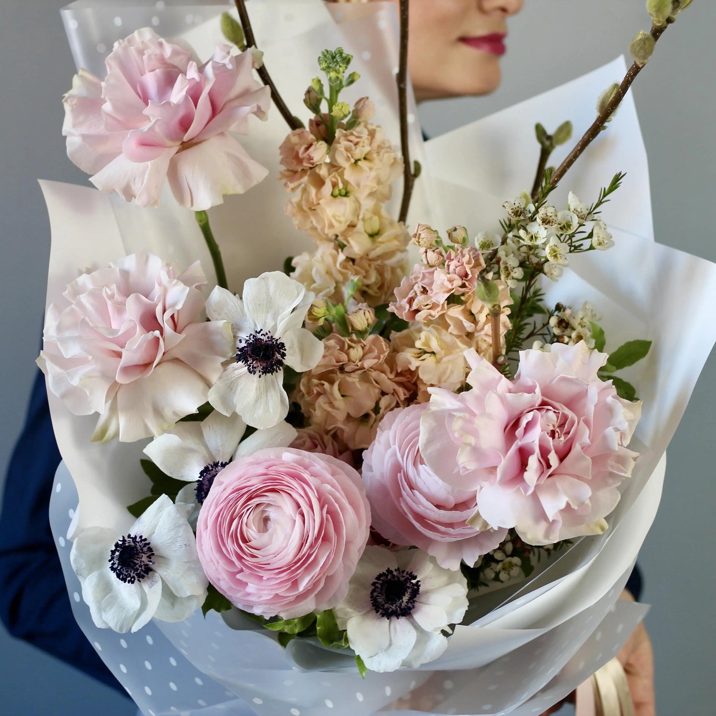Bouquet of ranunculus, anemones, garden roses, mathiola, and delicate spring branches