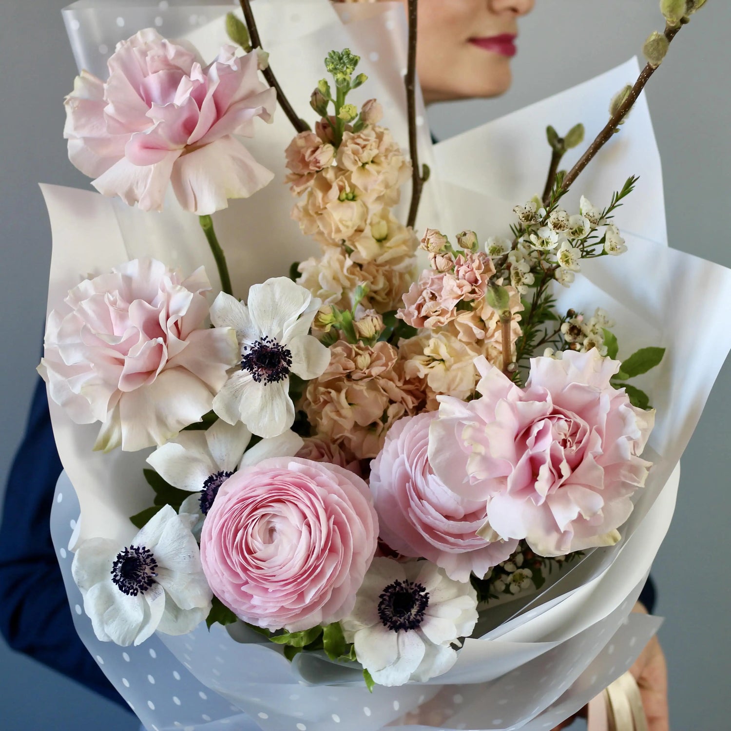 Bouquet of ranunculus, anemones, garden roses, mathiola, and delicate spring branches