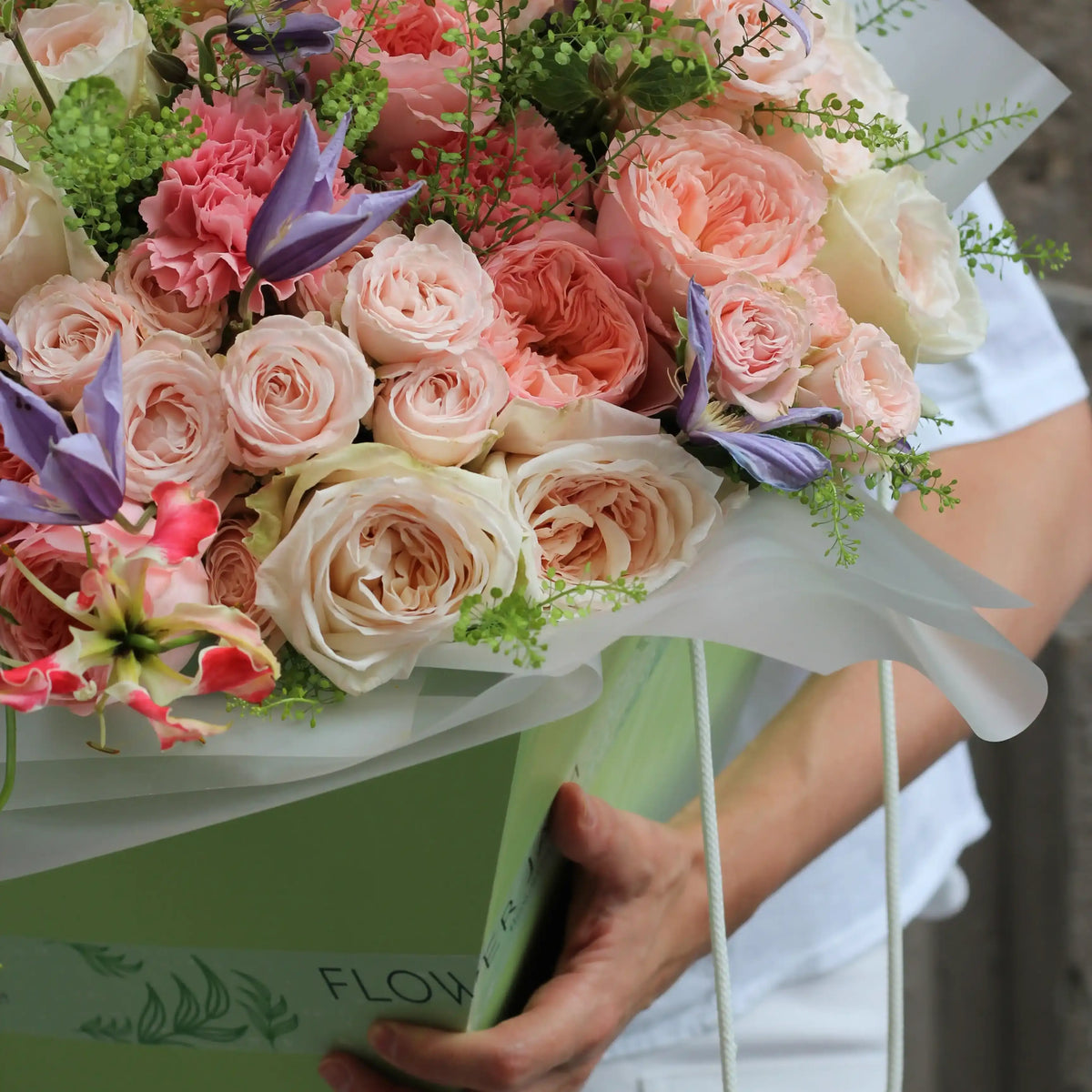 A close up on roses and gloriosa flowers inside a green transporttion box
