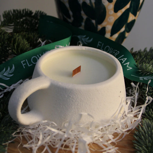 White candle in white cup
