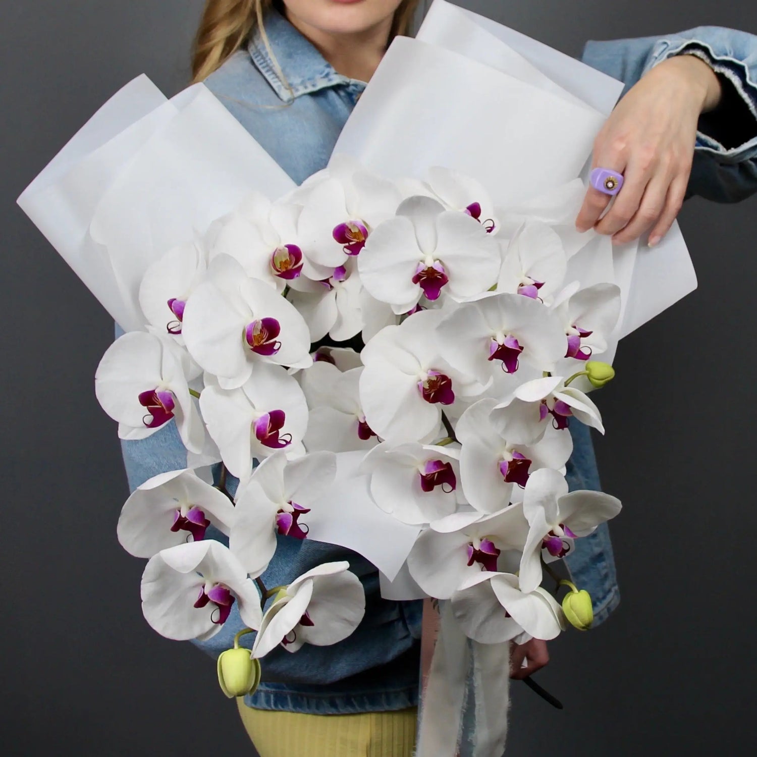 woman holding a bouquet of white orchids