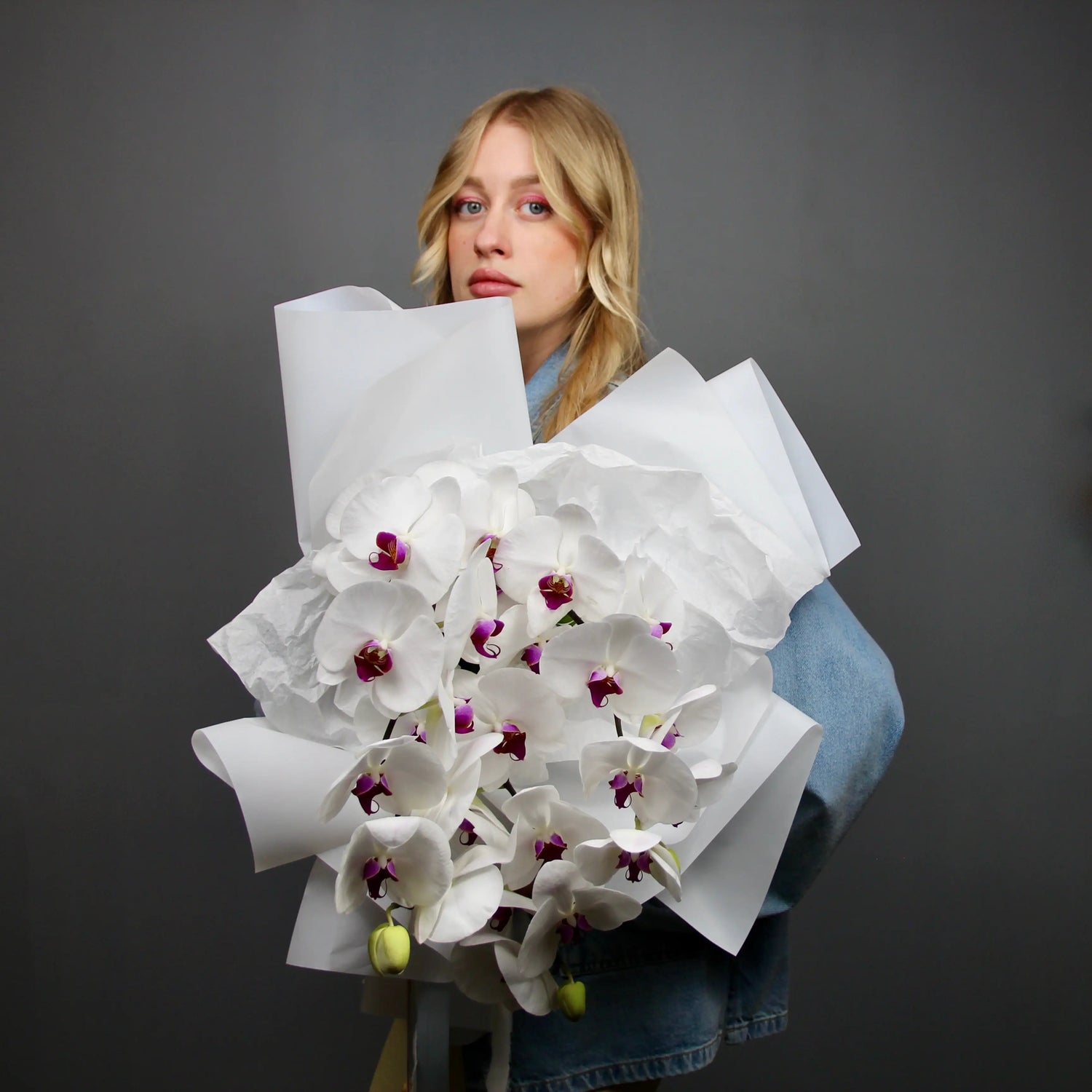 donna tiene un bouquet di orchidee