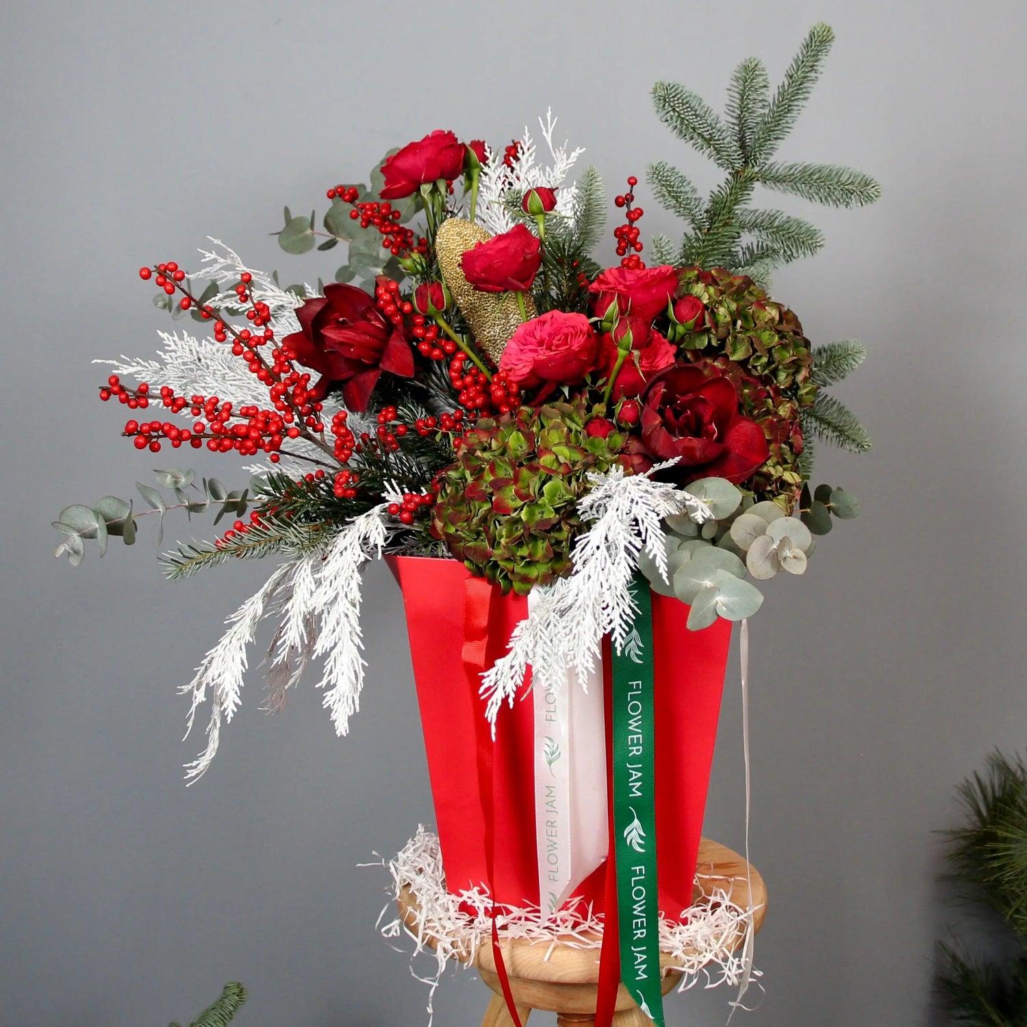 bouquet of red roses and spruce branches in a box