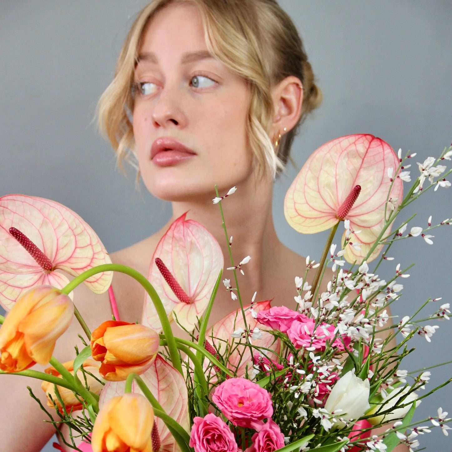 woman holding a bouquet of tulips and anthuriums