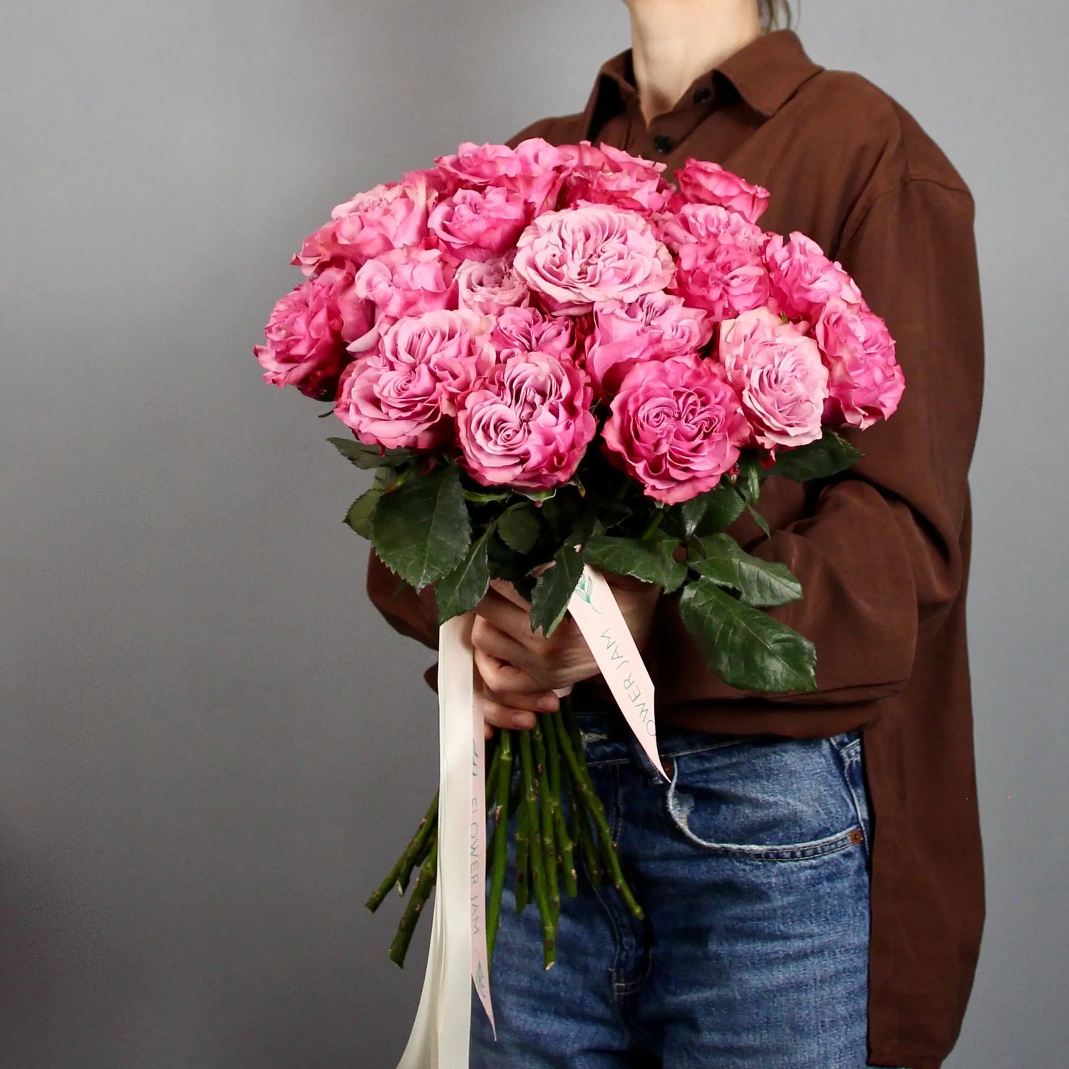 woman holding a big bouquet of pink garden roses 