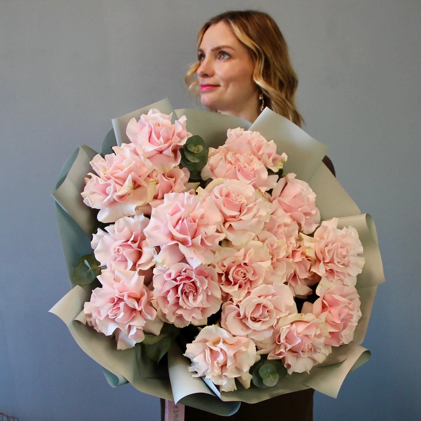 Woman holding a large bouquet of pink flowers roses with delvery in genova