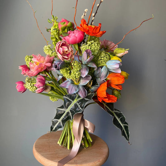 Bouquet of pink and blue tulips, pink peonies, poppies and viburnum