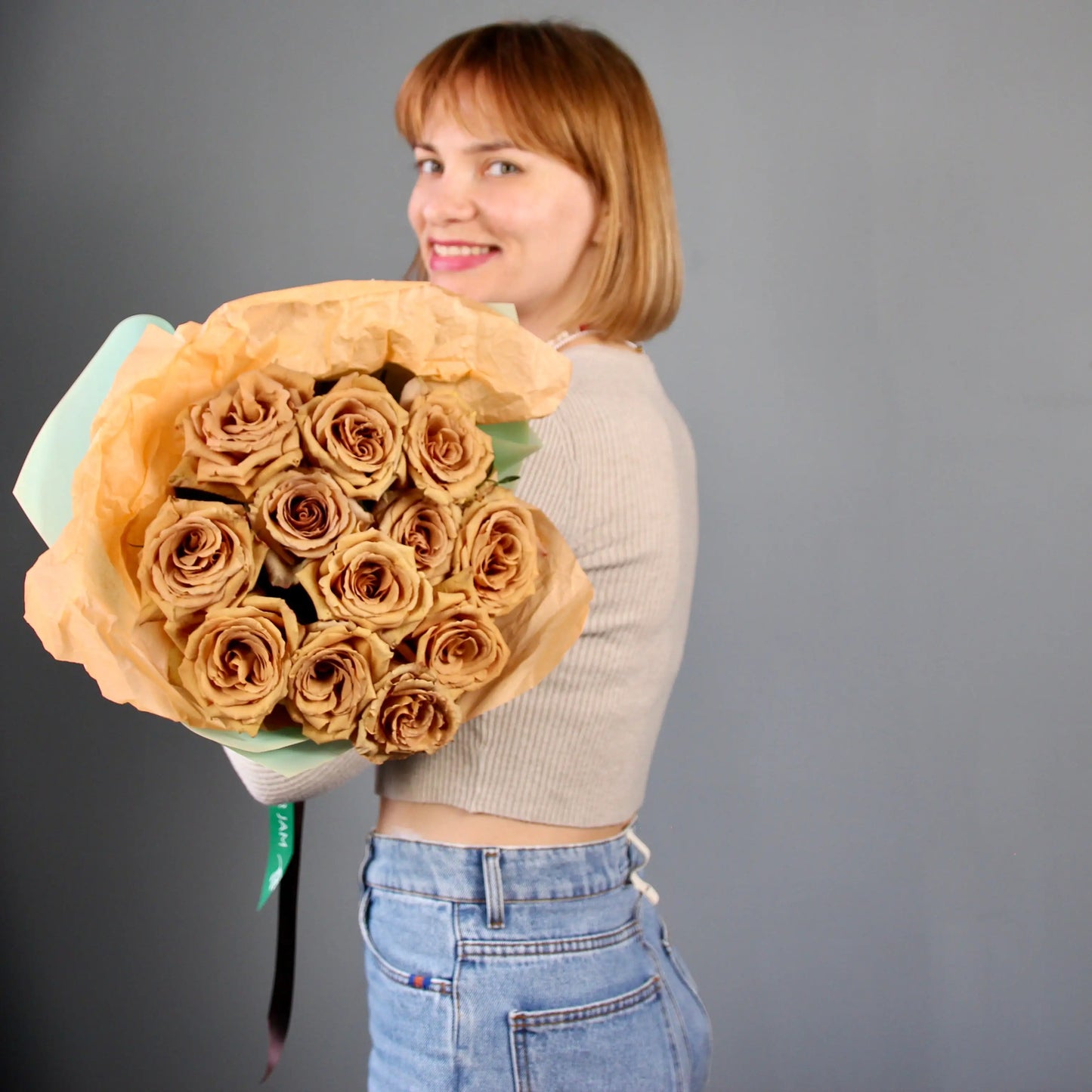 woman holding a bouquet of golden roses