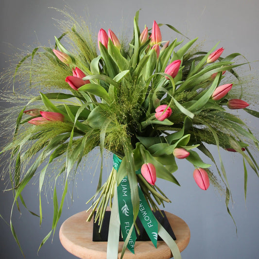 a big beautiful bouquet of pink tulips and greenery
